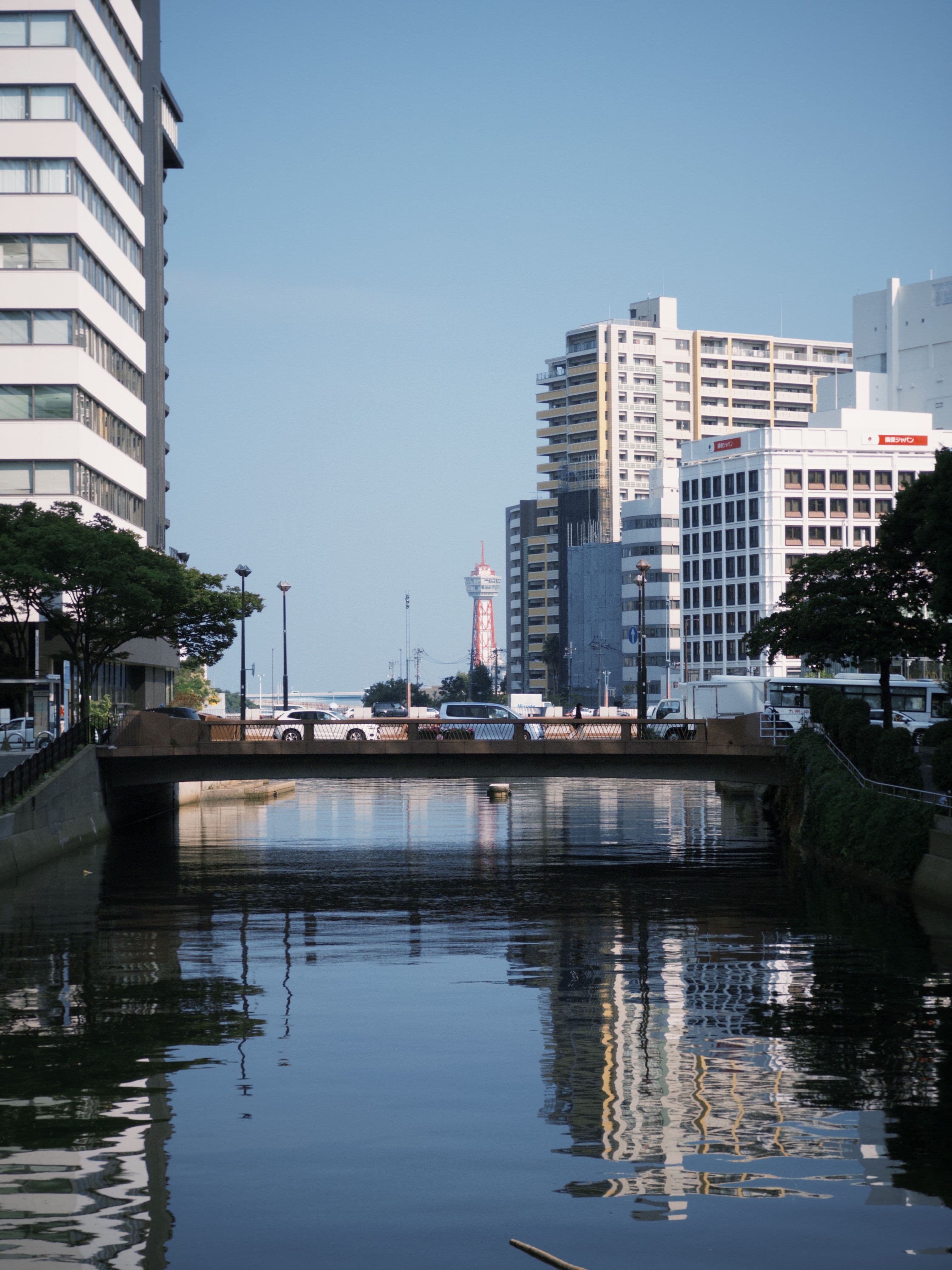 วิวคลองกลางเมืองฟุกุโอกะสะท้อนตึกสมัยใหม่ยามกลางวัน