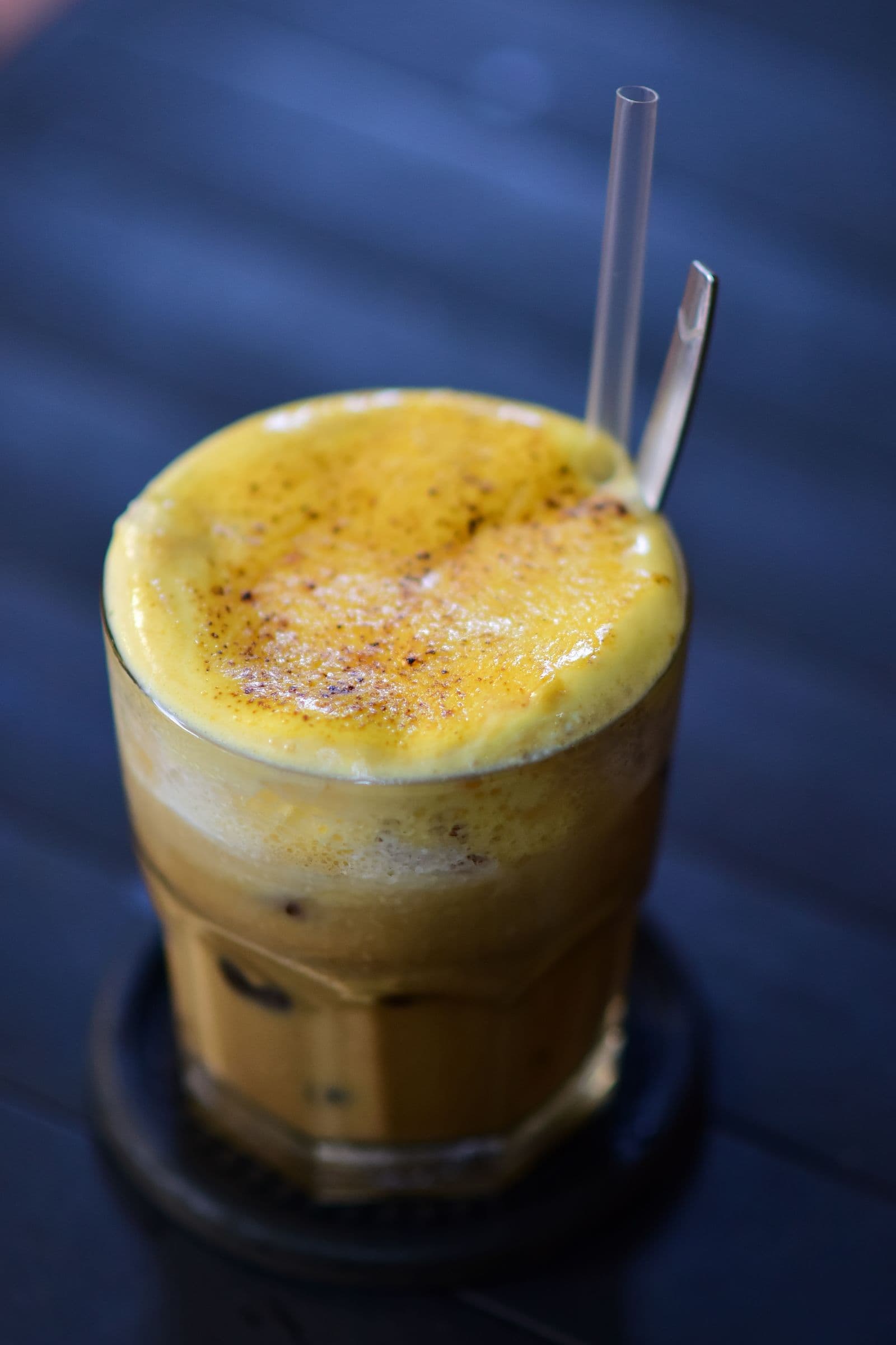 กาแฟไข่ฮานอยในแก้วใส ด้านบนเป็นฟองครีมไข่สีเหลืองนวล
