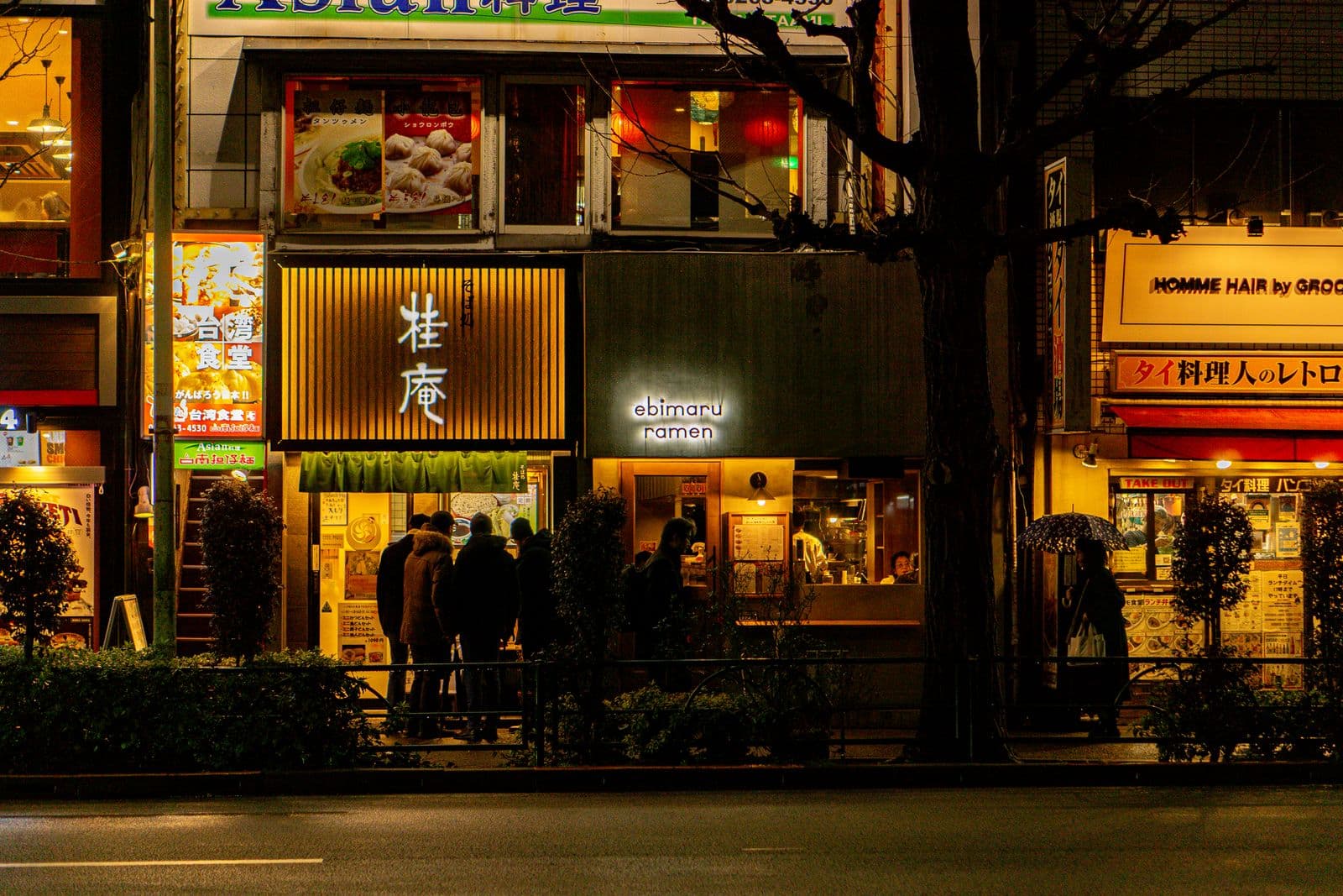 ร้านราเมนเปิดไฟเรียงกันริมถนนในโตเกียวยามค่ำ